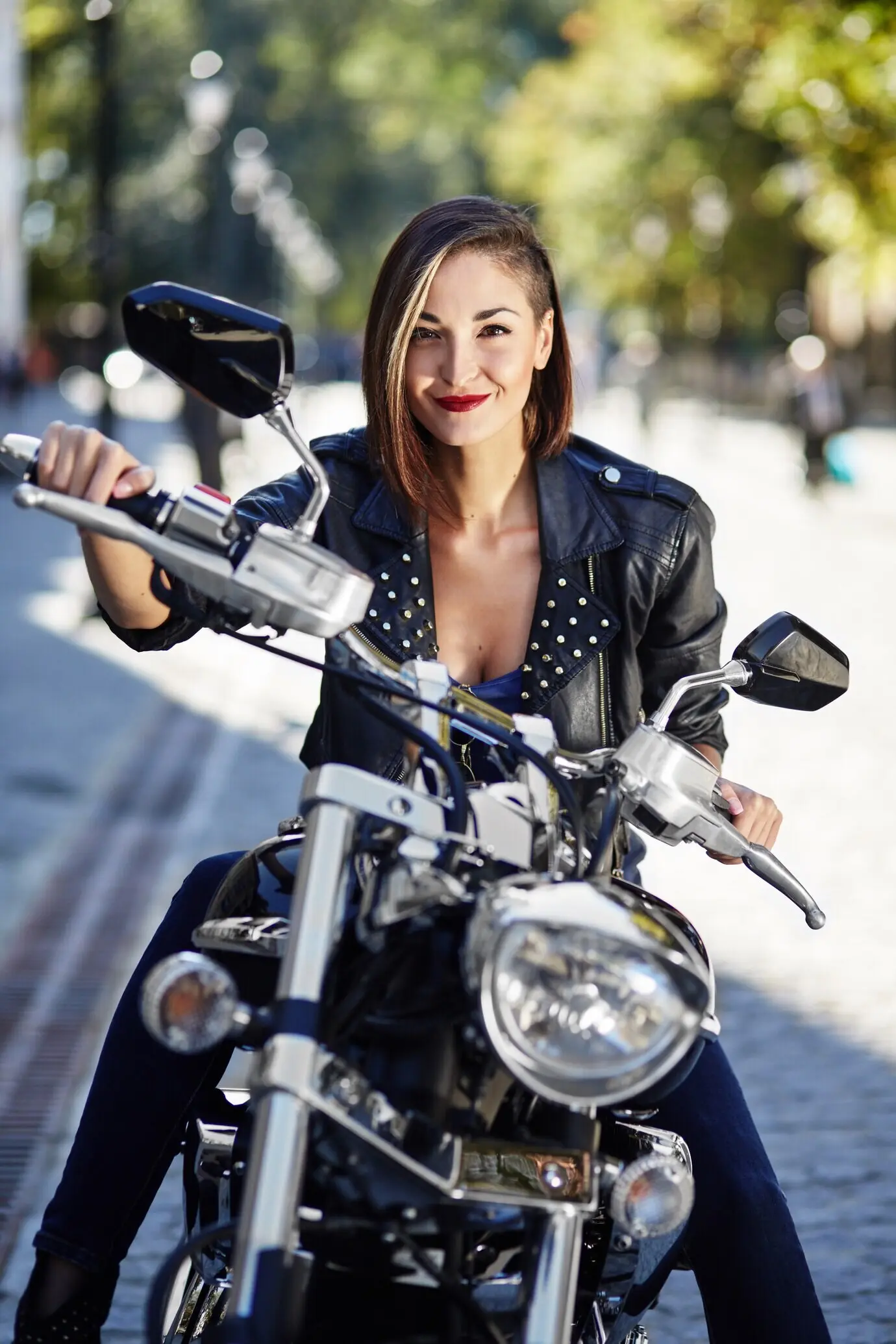 Biker-Girl in einer Lederjacke auf einem Motorrad